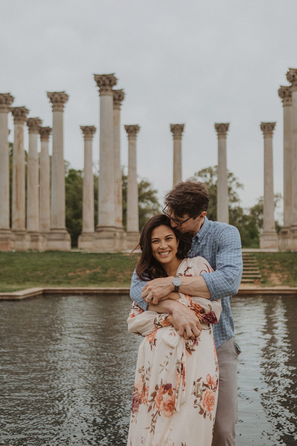 couple embraces in front of National Columns reflecting pool at National Arboretum DC