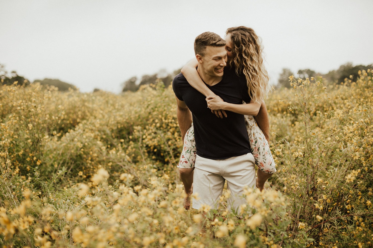 Man carries woman through flower field at National Arboretum DC engagement session