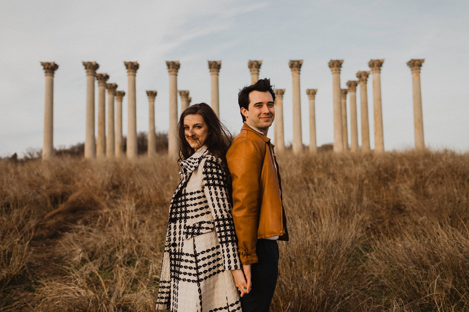 Couple stands back to back at National Arboretum DC engagement session