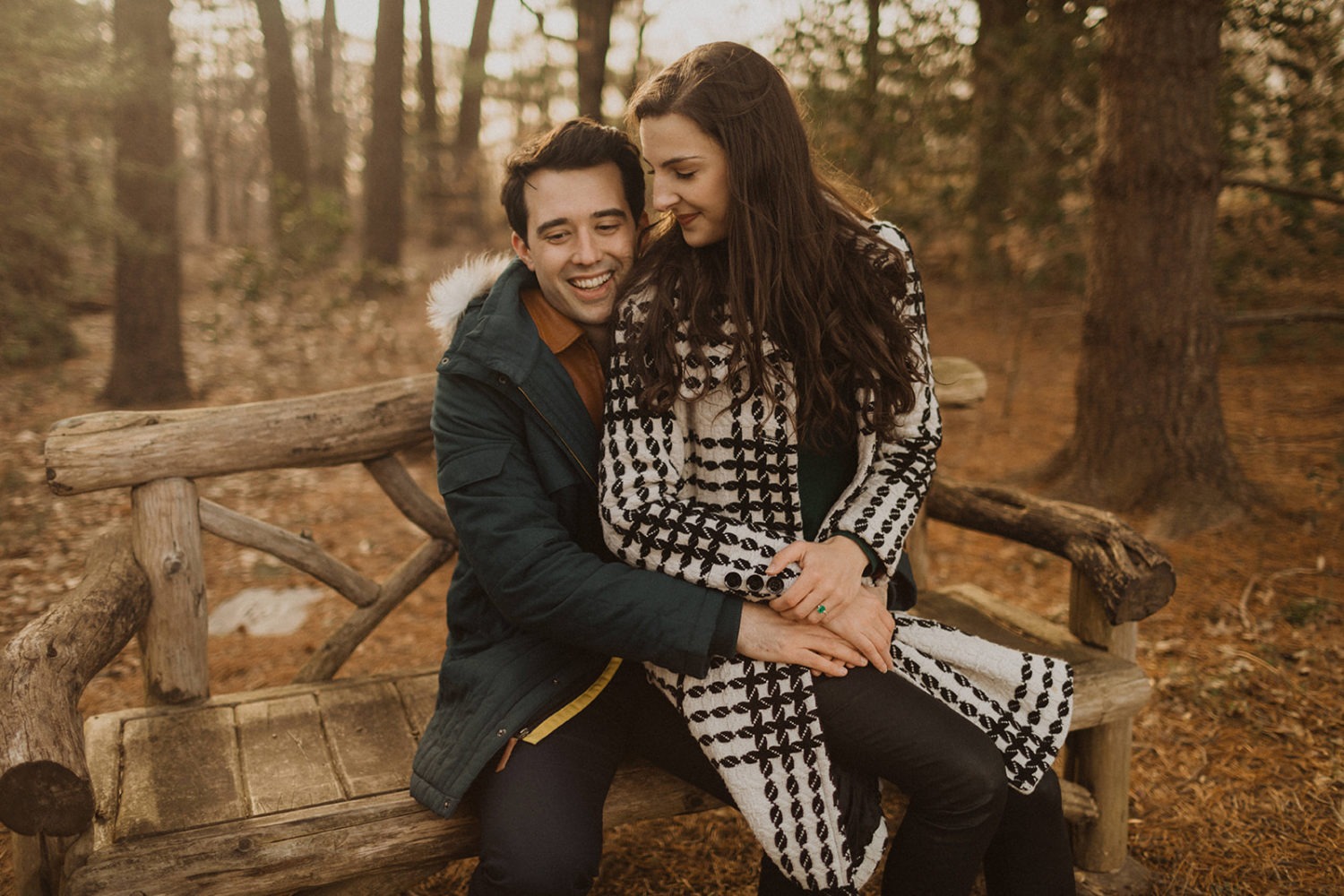 couple sits on bench at winter engagement session
