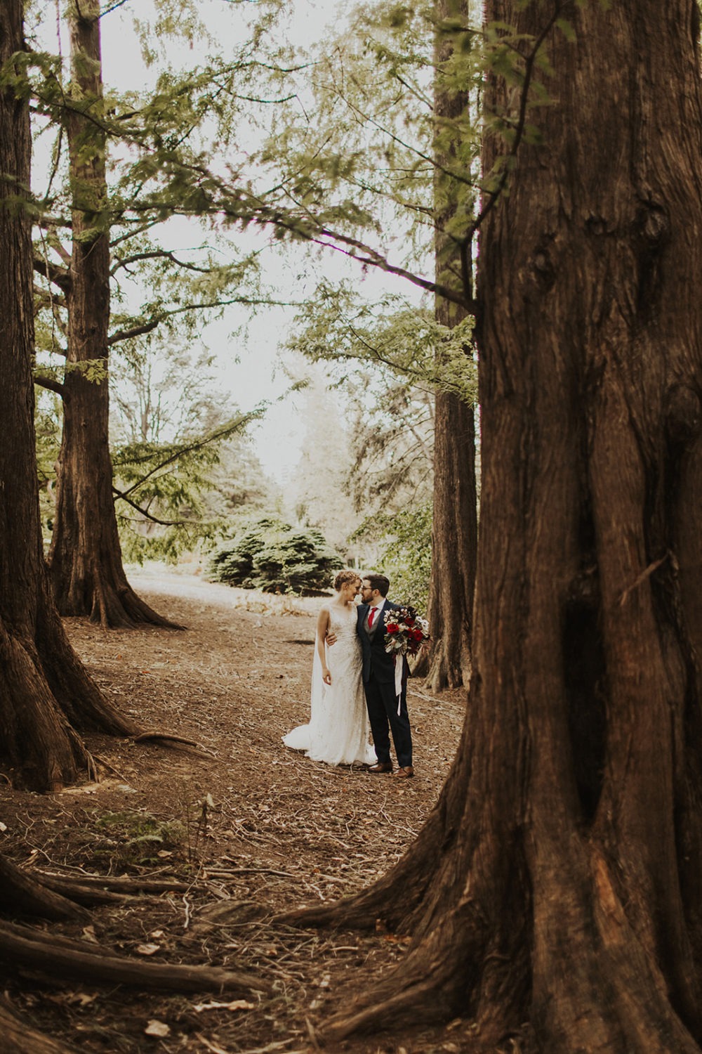 couple walks through woods at woods wedding first look