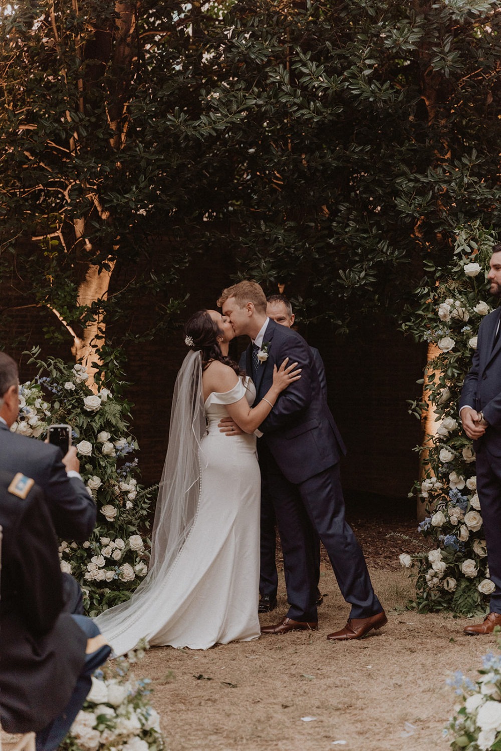 couple kisses during DC Anderson House garden outdoor wedding