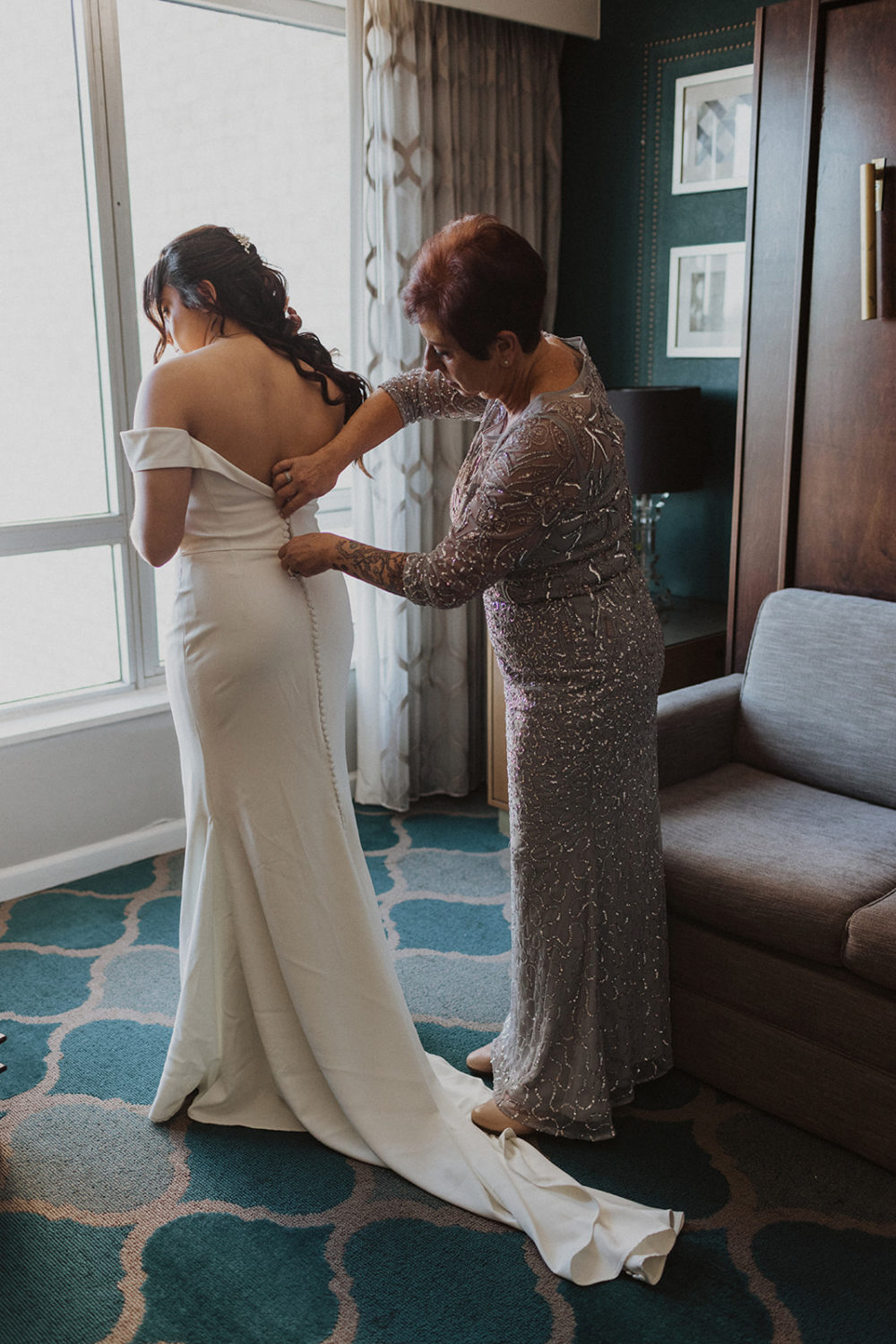 mom buttons bride's dress in DC hotel at urban wedding