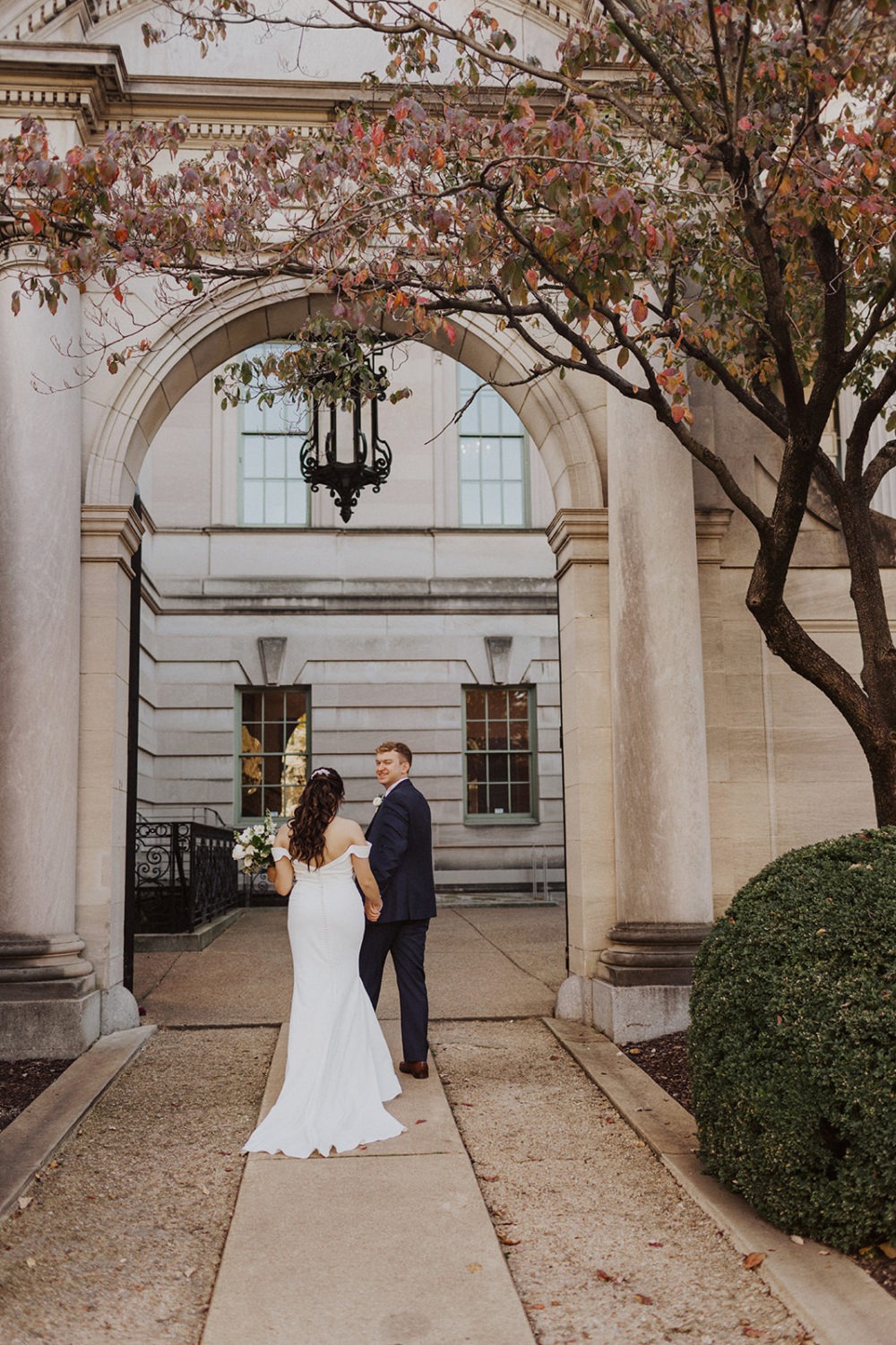couple walks through archway at DC estate 