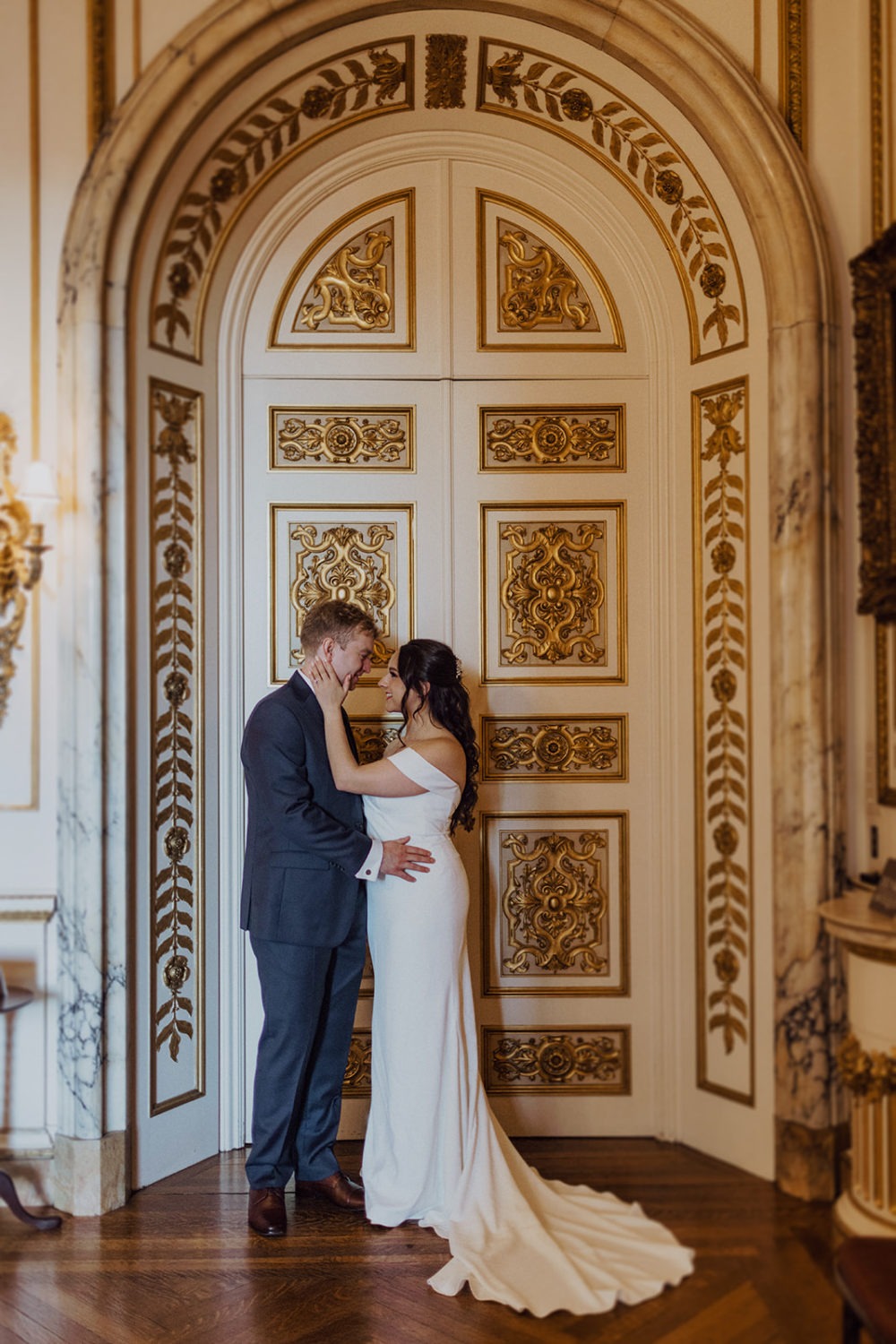 couple stands outside of gold doorway at DC historic estate wedding