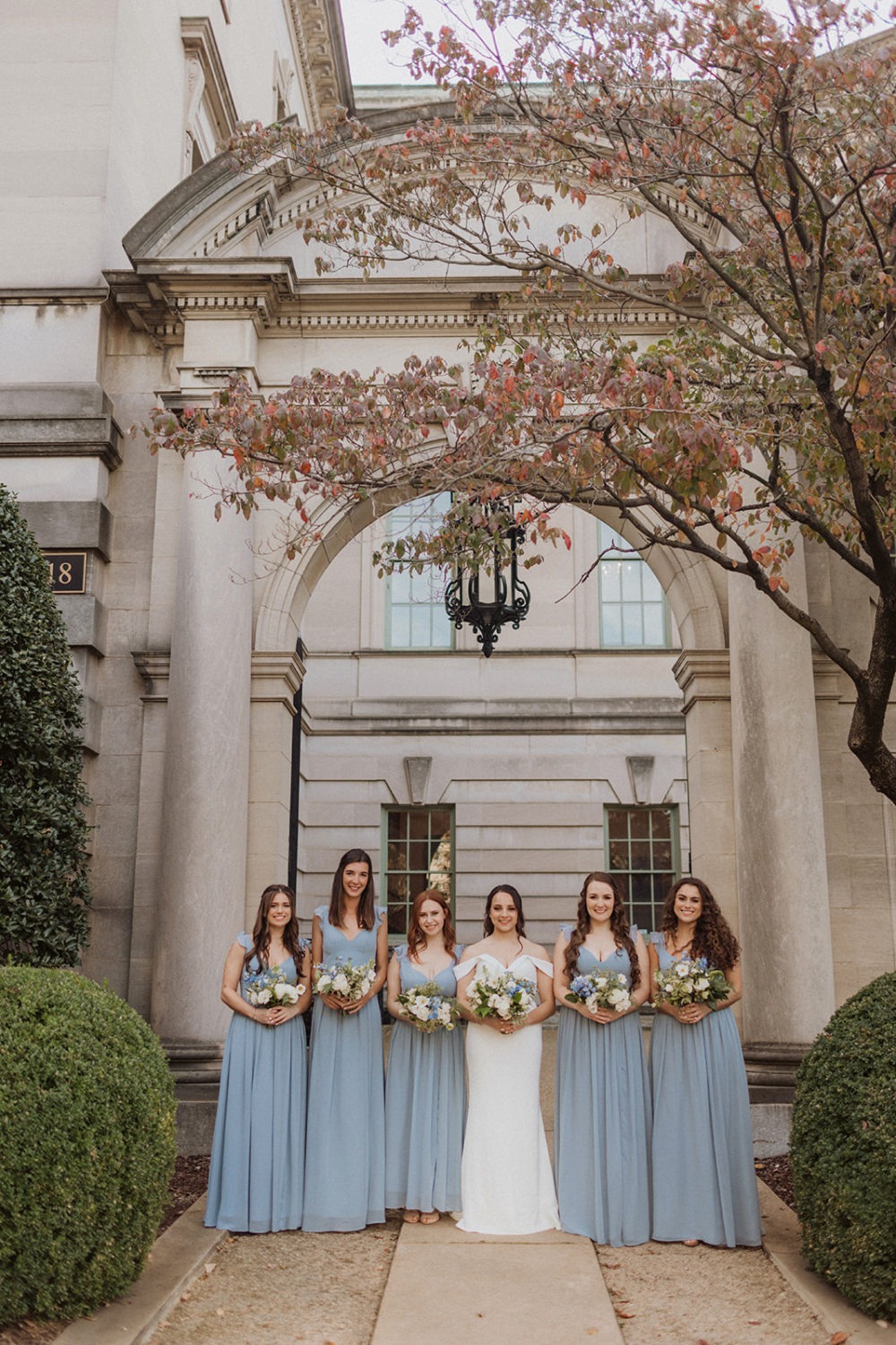 bridesmaids stand in front of columns at DC estate