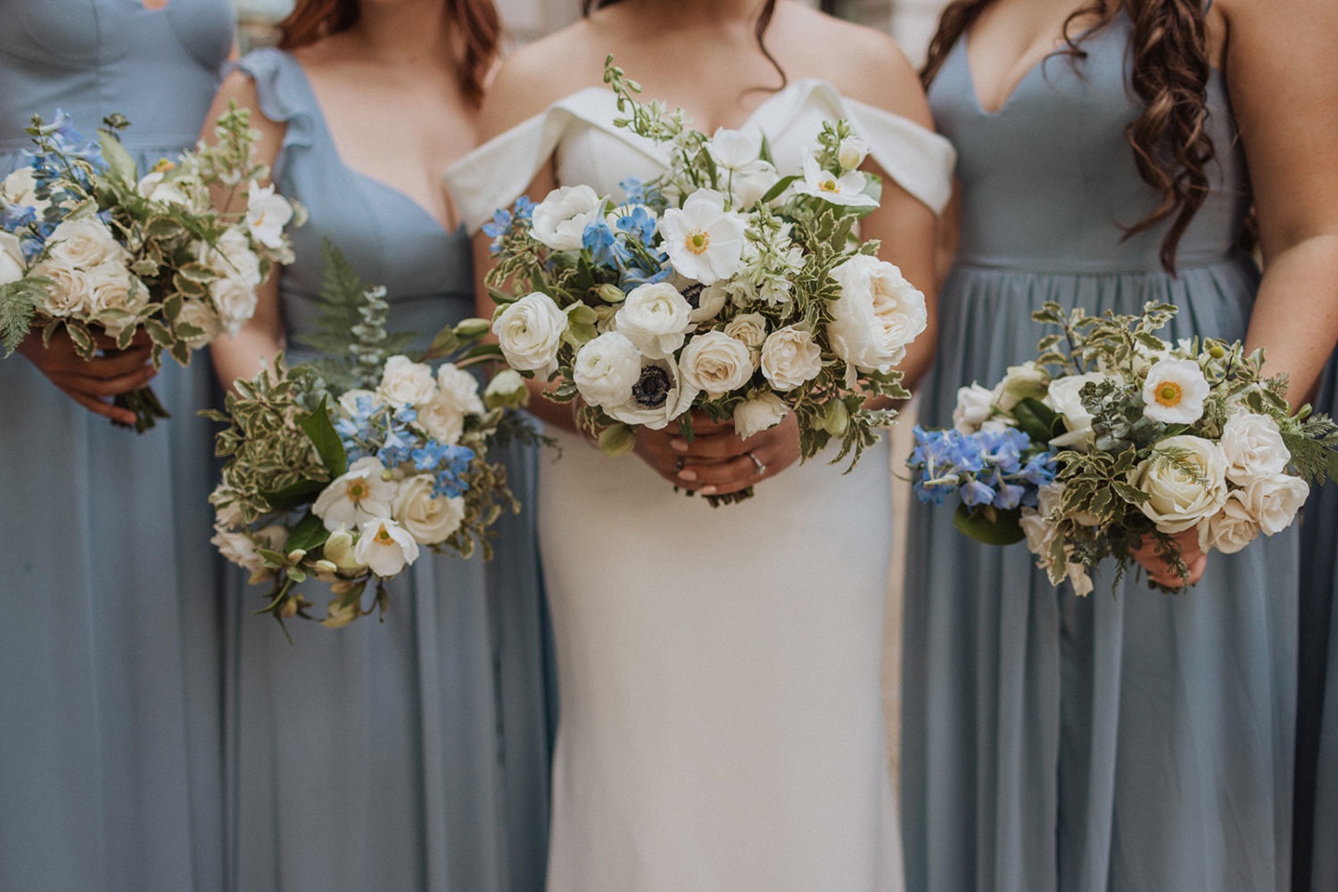 bride and bridesmaids hold white and blue wedding bouquets at DC mansion wedding venue