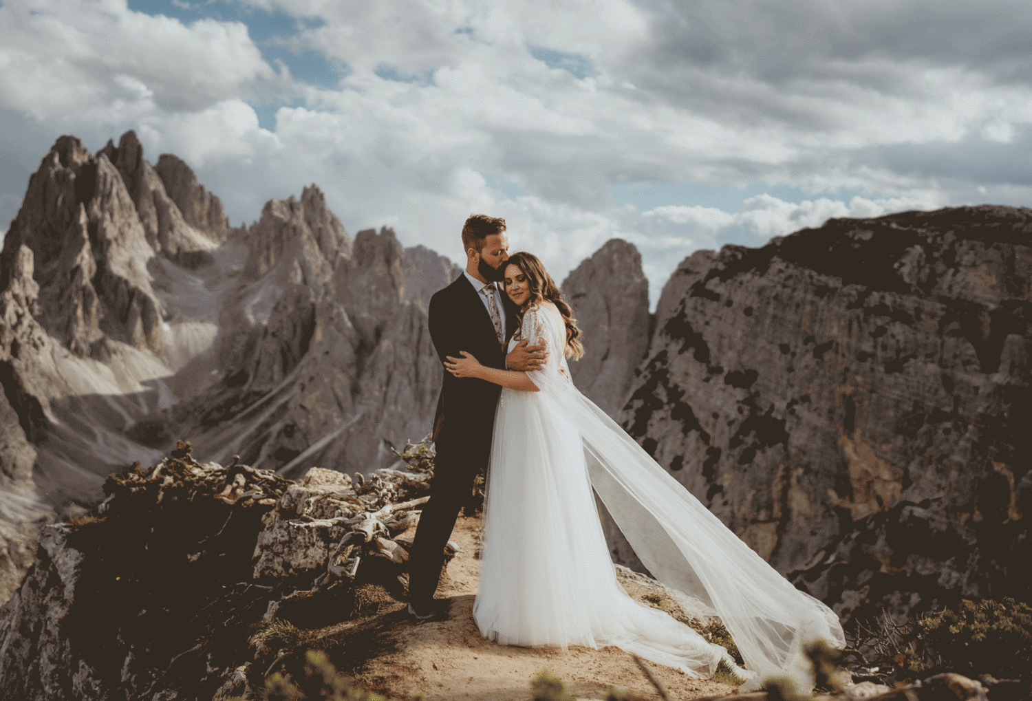 couple embraces on mountaintop at Italian Dolomites elopement