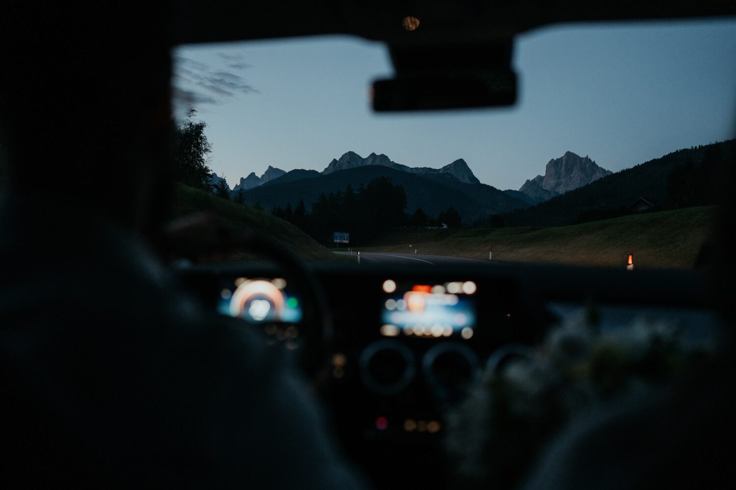 couple drives in car approaching the Dolomites at Italy elopement
