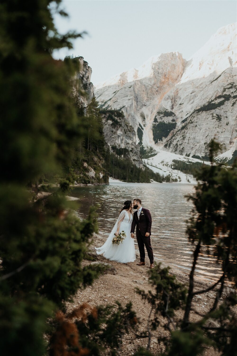 couple kisses lakeside at the Dolomites Italy elopement 