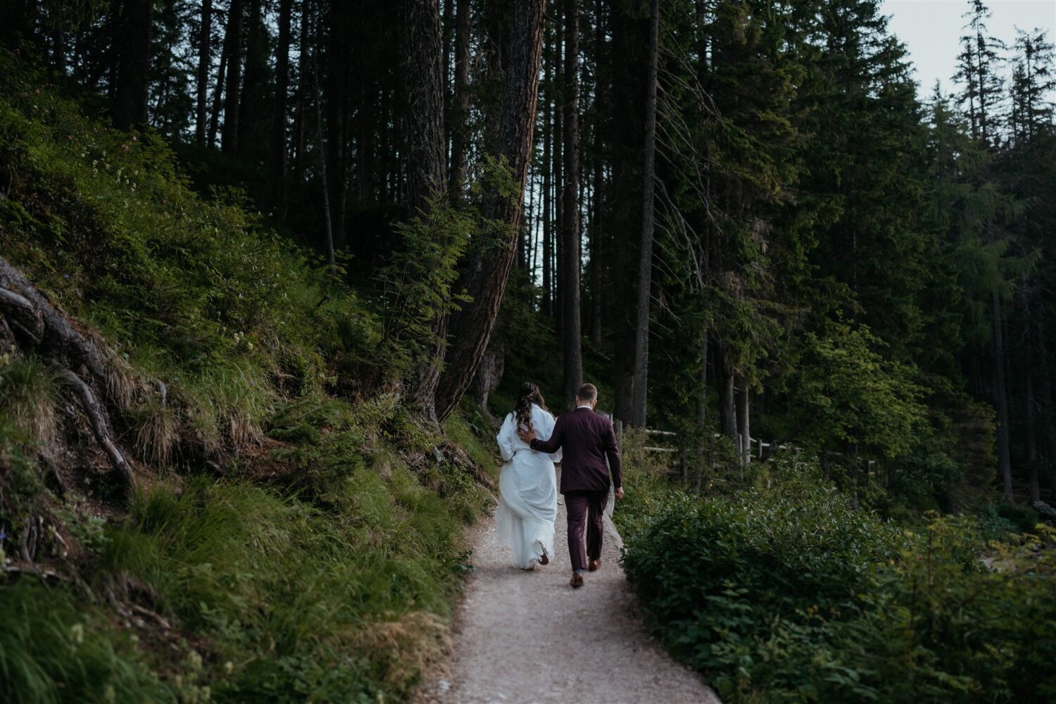 couple walks through woods for Italian Dolomites first look