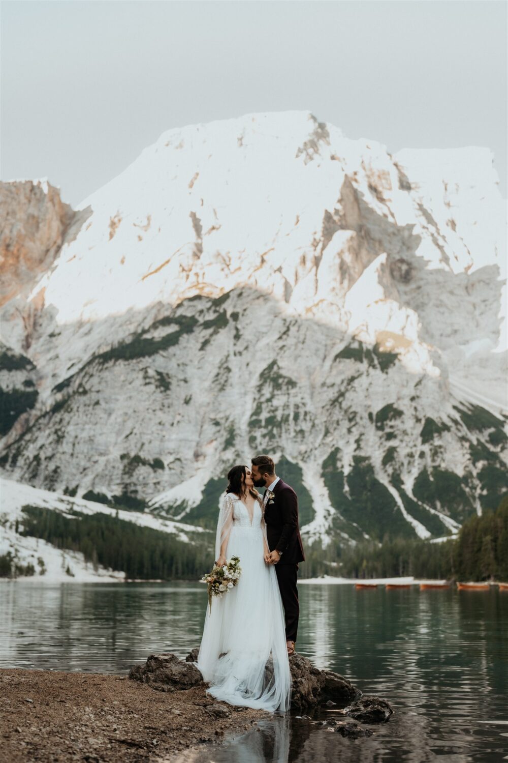 couple kisses lakeside at the Dolomites Italy elopement 