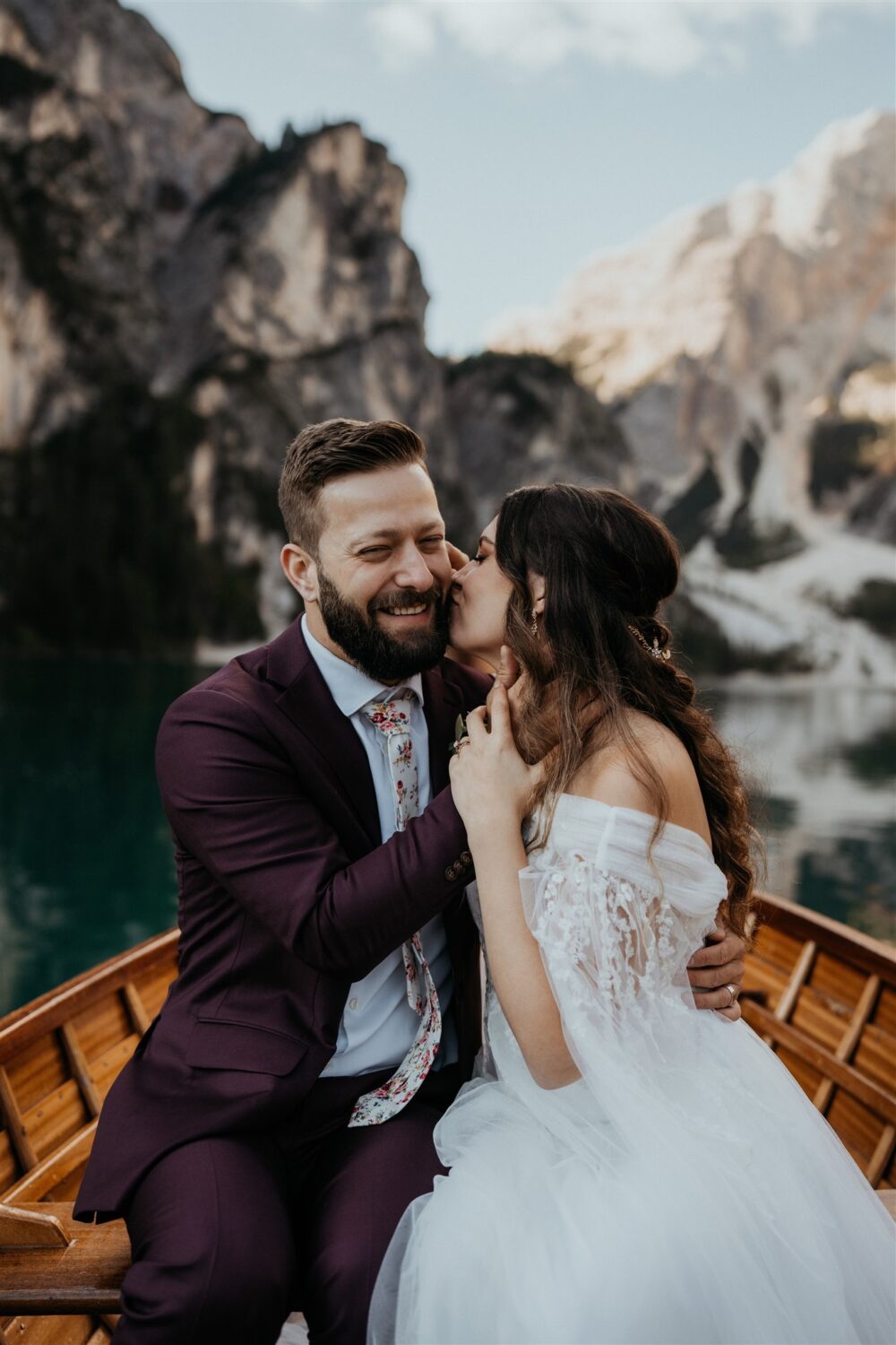 couple kisses in boat at Italy elopement beside the Dolomites