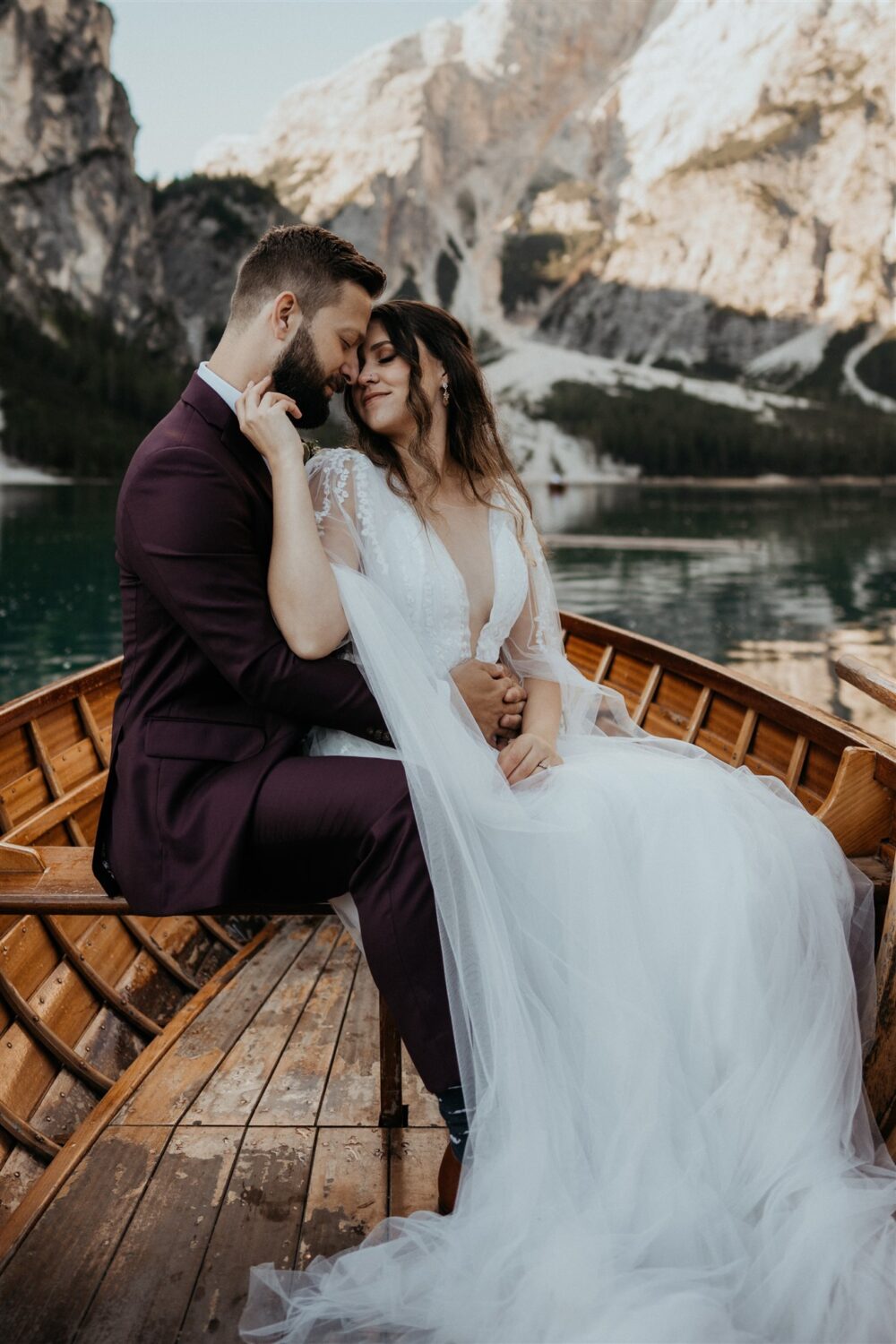 couple snuggles in boat at Italy elopement beside the Dolomites