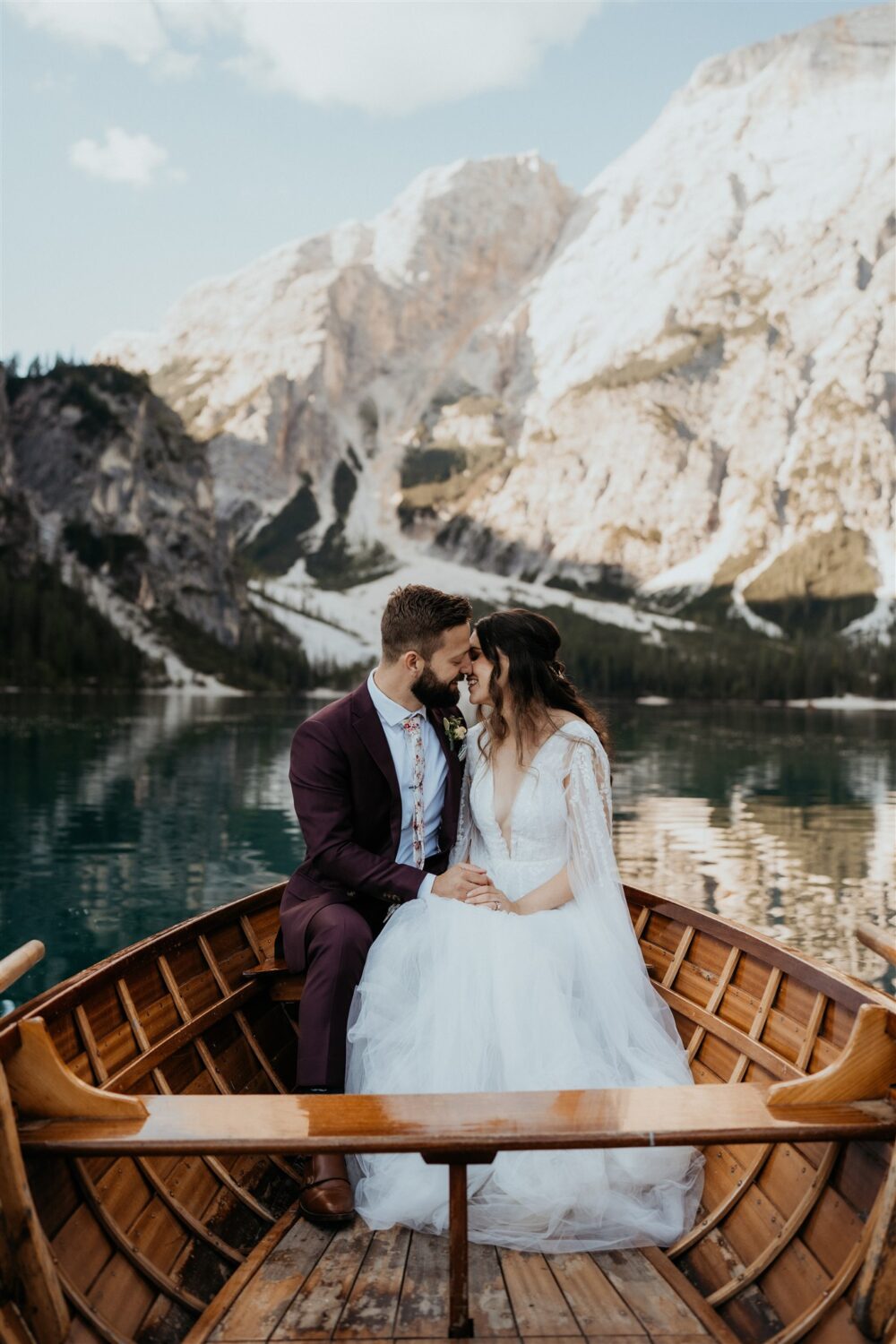 couple kisses in boat at Italy elopement beside the Dolomites