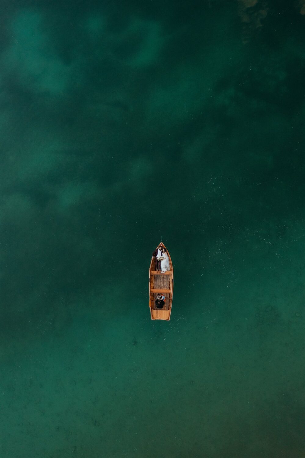 couple lays down in boat at Italy elopement beside the Dolomites