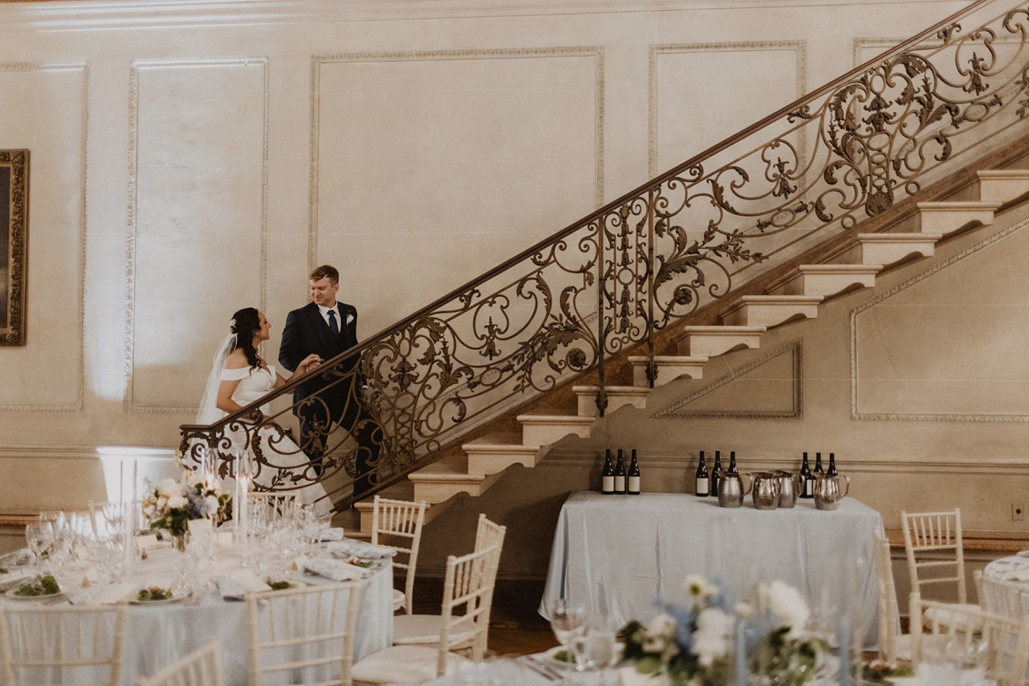 couple walks up iron staircase at mansion wedding venue