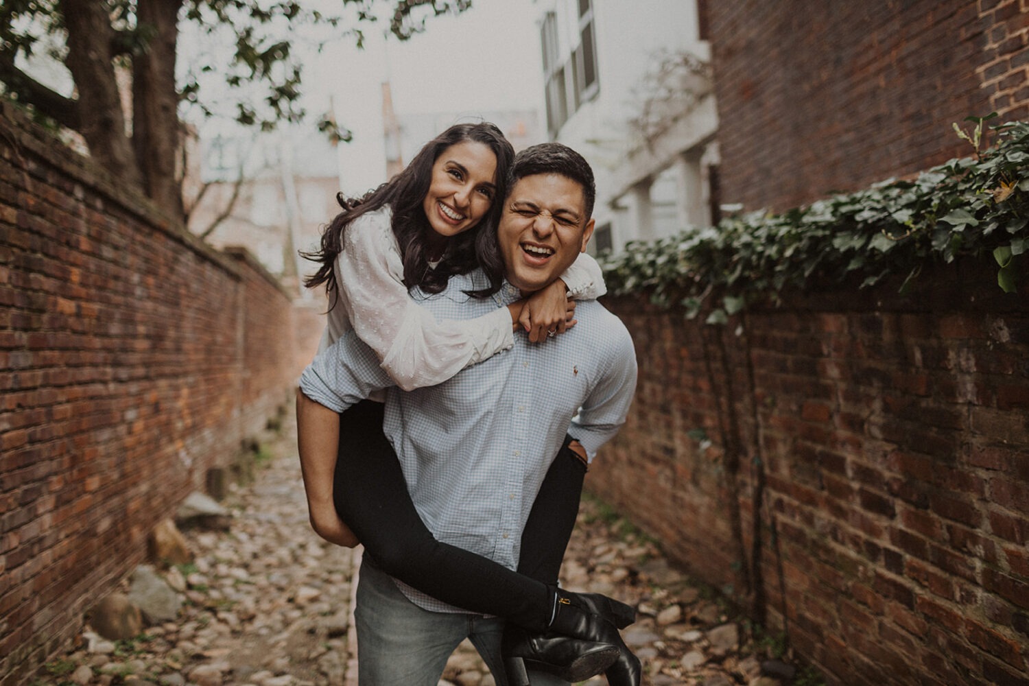 couple walks through alleyway at old town alexandria engagement session