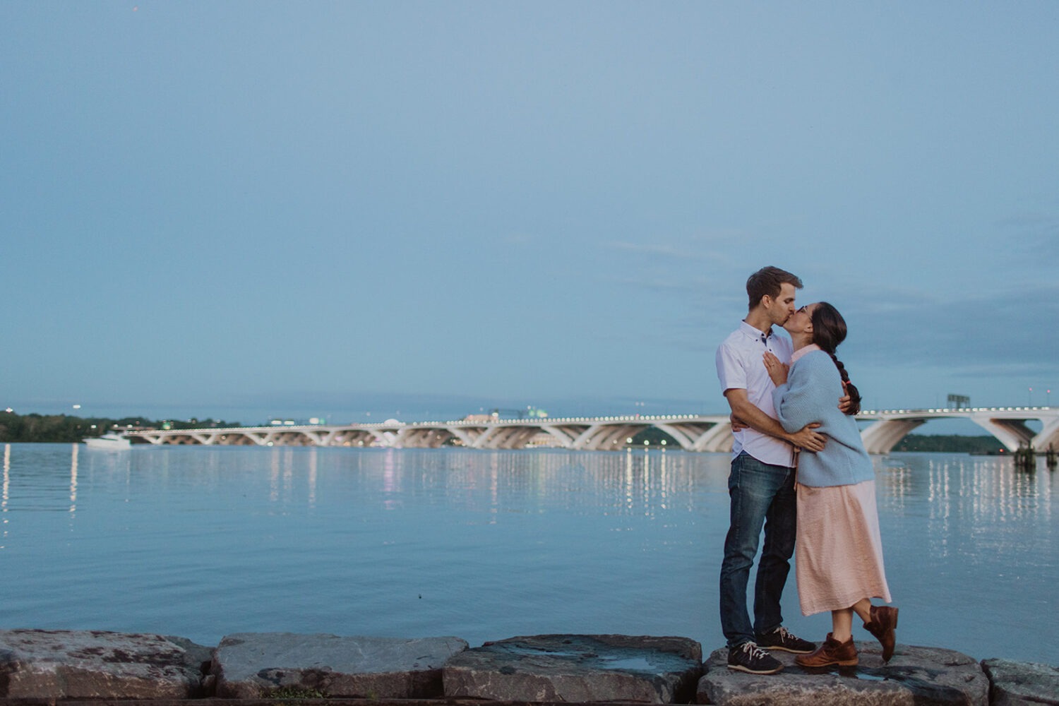 couple kisses by water at Old Town Alexandria waterfront engagement session