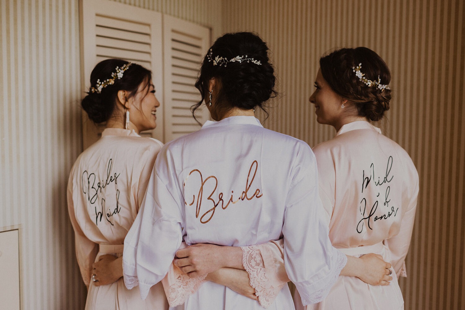 bride stands beside bridesmaids with matching monogrammed silk robes
