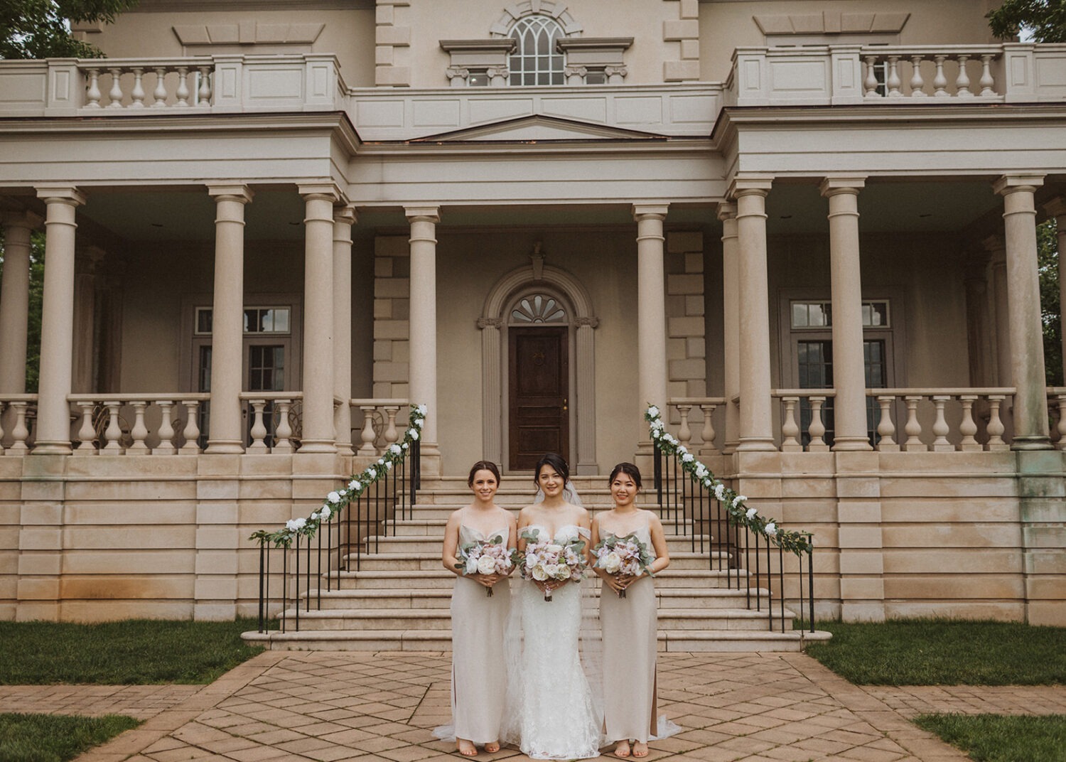 bride stands with bridesmaids holding bouquets at Virginia wedding venue