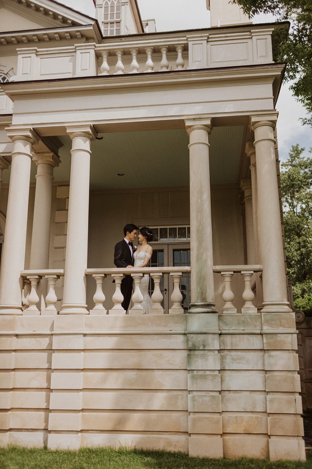 couple has first look under columns on patio at Virginia wedding venue