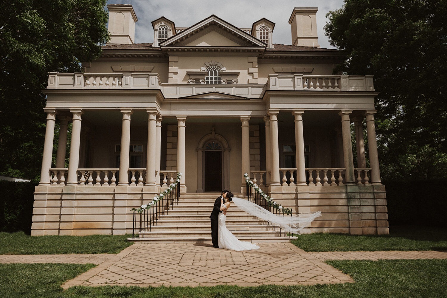 couple kisses in front of mansion at Virginia wedding venue