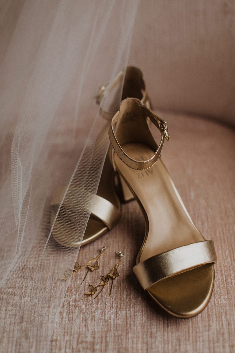 gold shoes and earrings under wedding veil