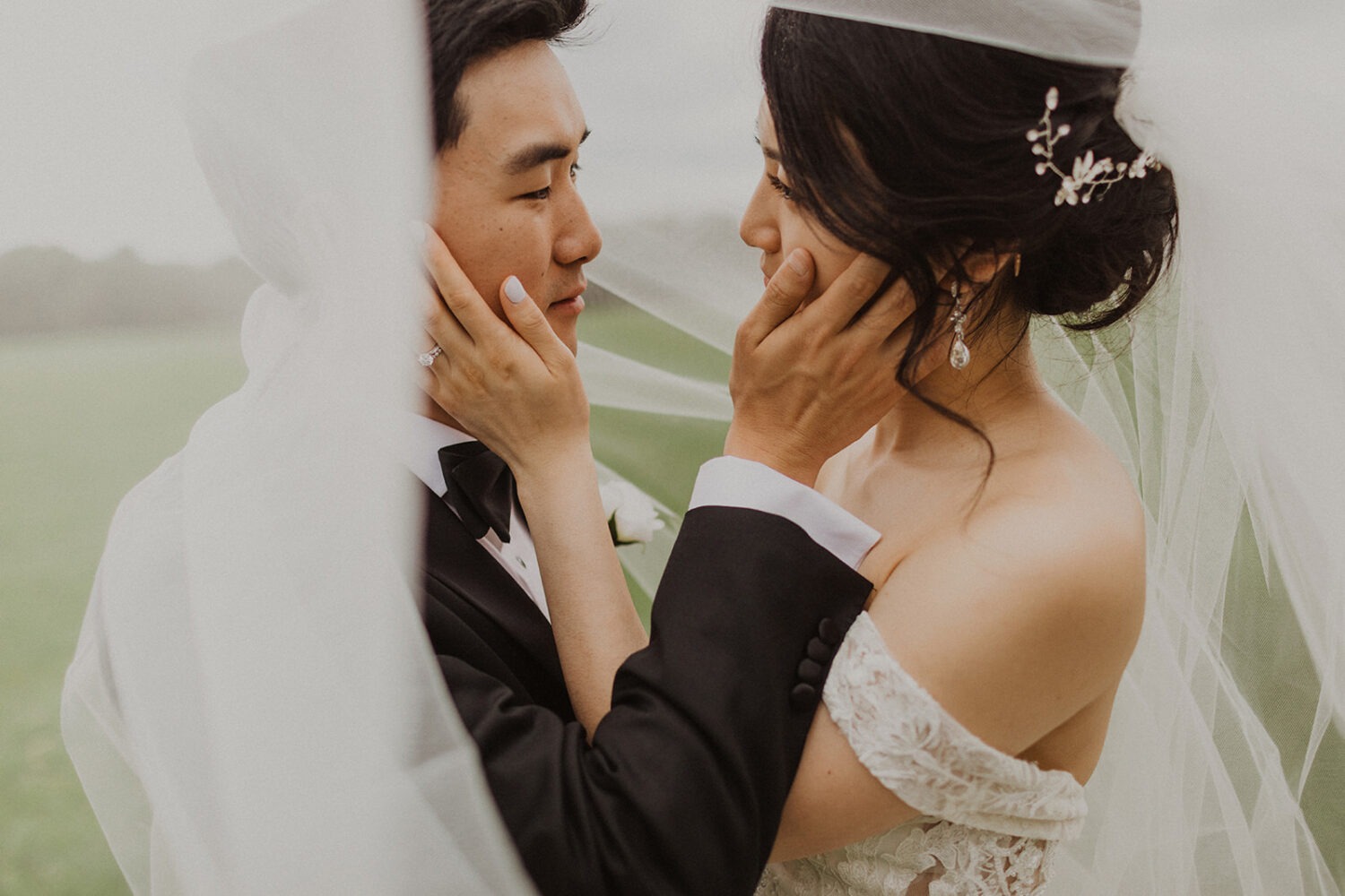 couple embraces under wedding veil 