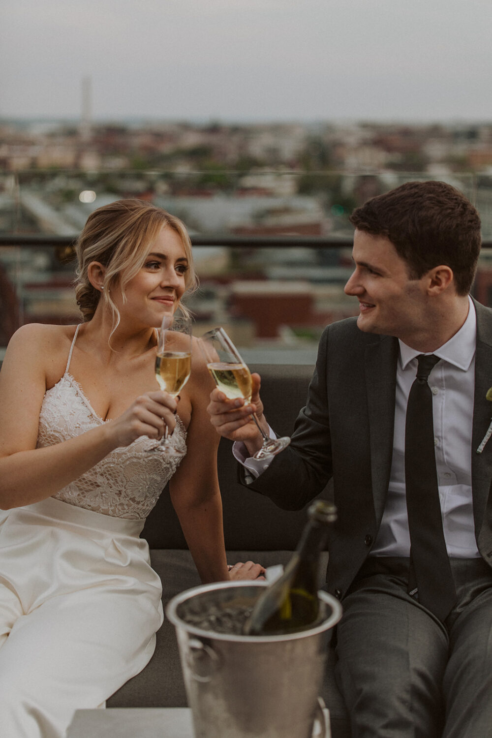 couple toasts with champagne at DC rooftop elopement 