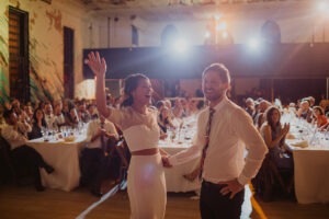 couple laughs together standing on dance floor at wedding reception