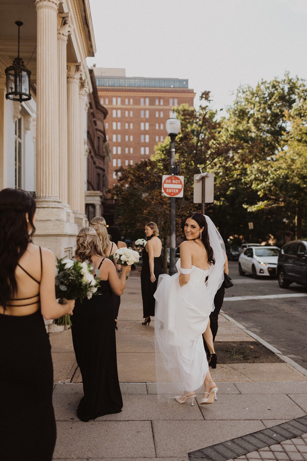 bride walks through city streets with bridesmaids in Baltimore