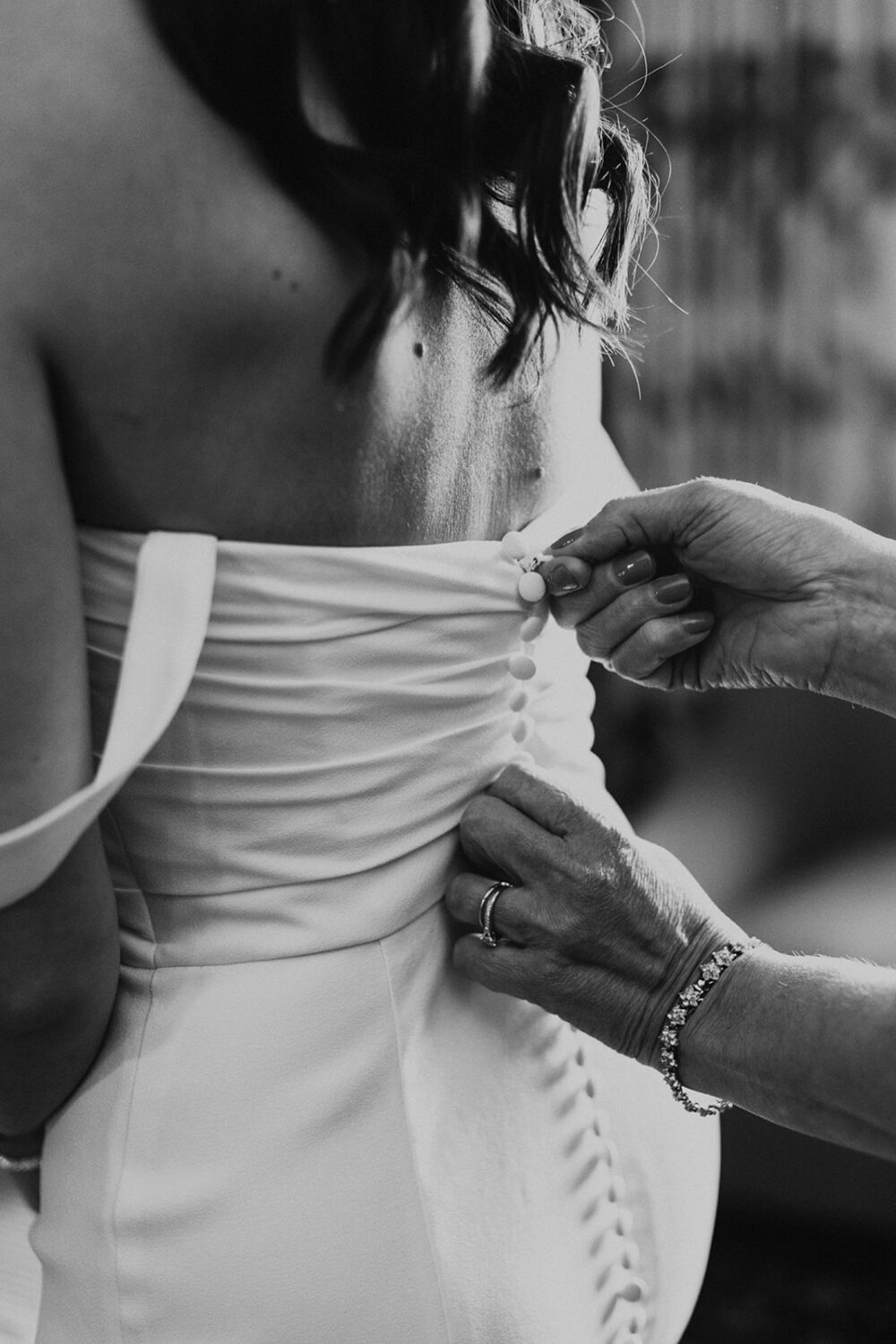mom buttons up bride's wedding dress