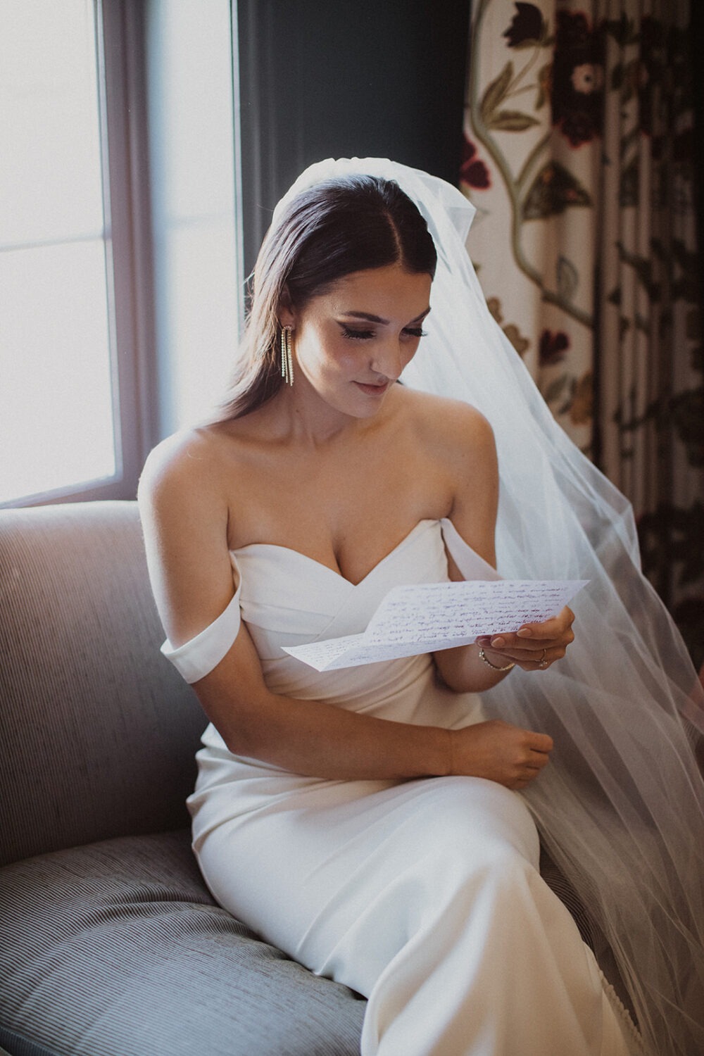 bride reads letter from groom while getting ready at hotel