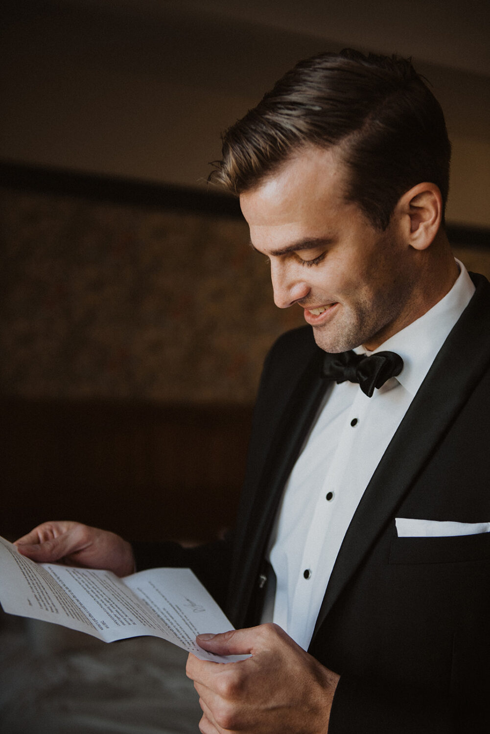 groom read letter from bride while getting ready at hotel