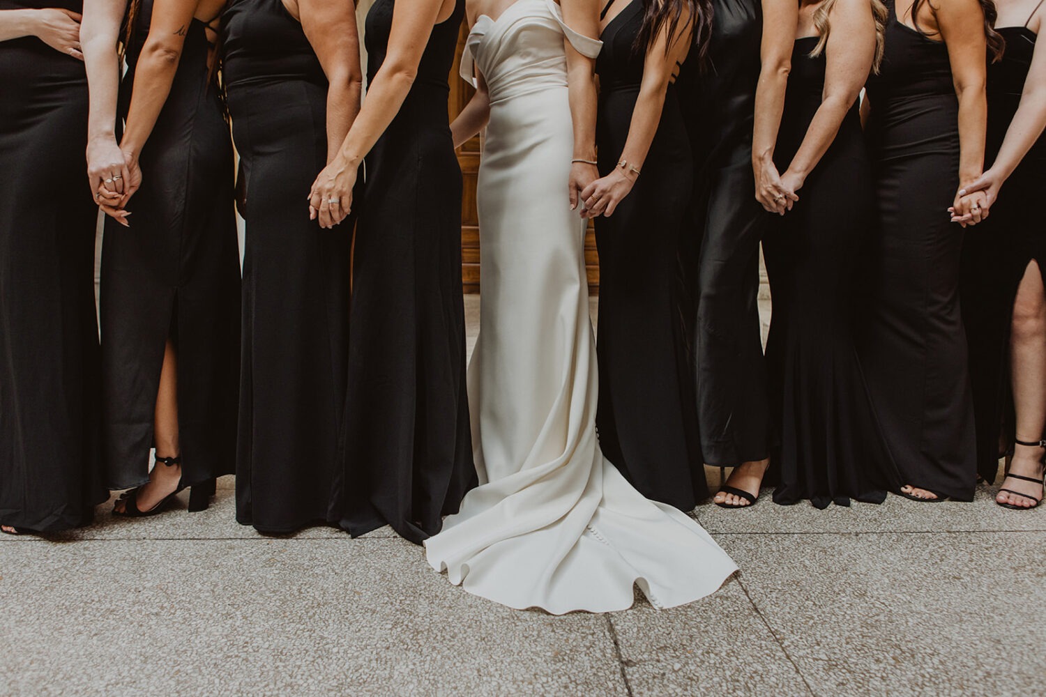 bridesmaids stand together holding hands