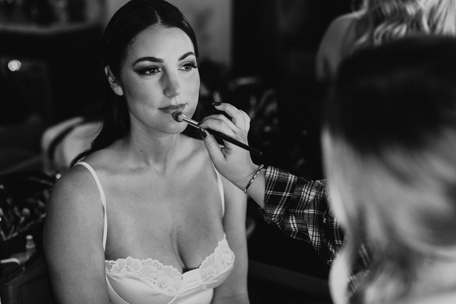 bride has makeup done during wedding getting ready