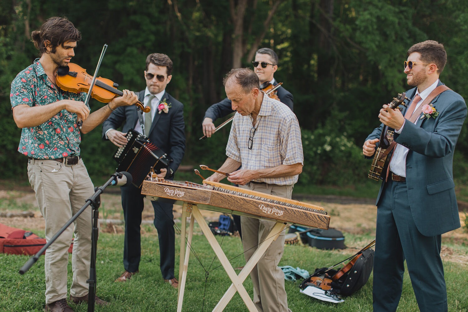 groomsmen play with musicians at bluegrass theme wedding 