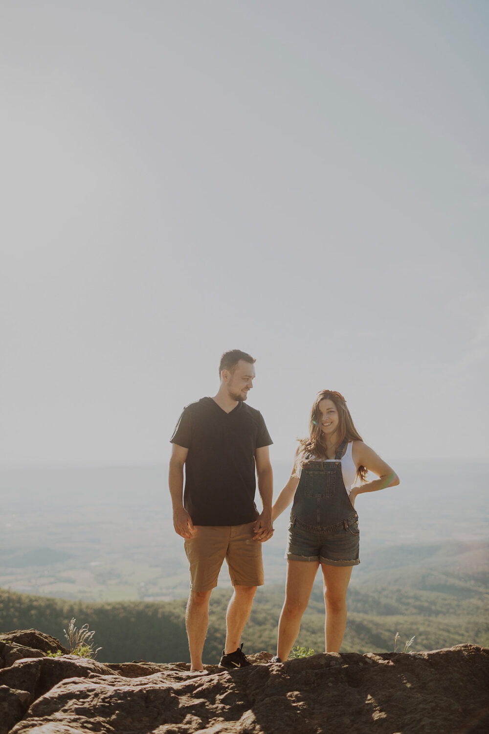 couple holds hands on mountaintop at Shenandoah National Park maternity session