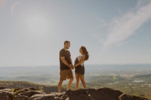 couple stands holding hands on mountaintop at Shenandoah National Park