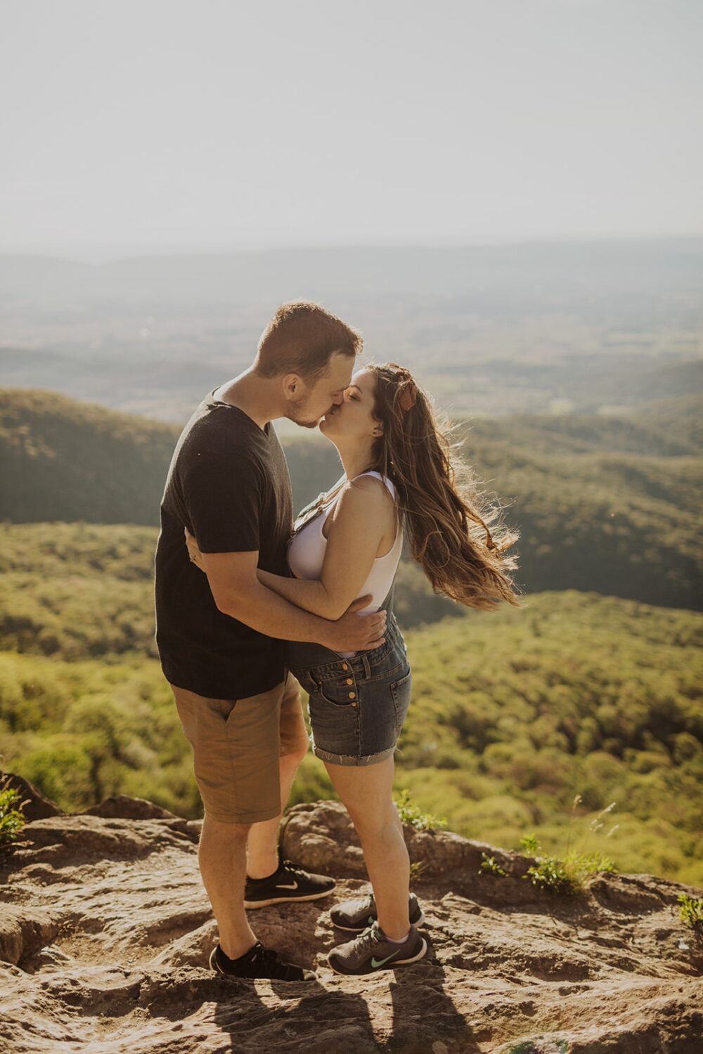 couples kisses on top of mountain in Shenandoah National Park