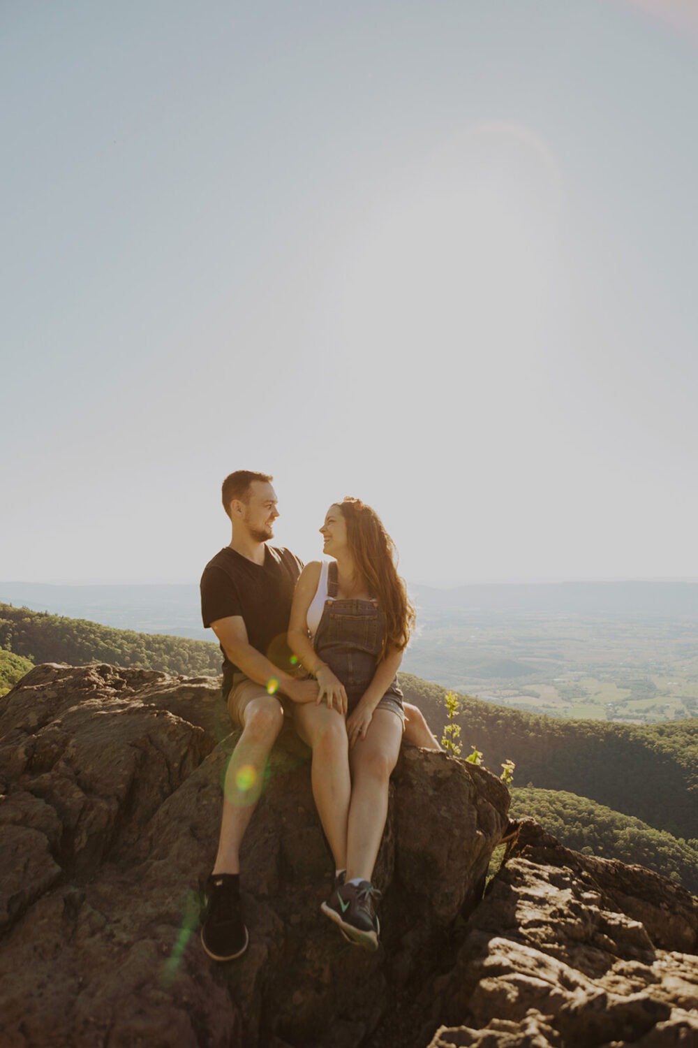 Couples sits on top of mountain in Shenandoah National Park