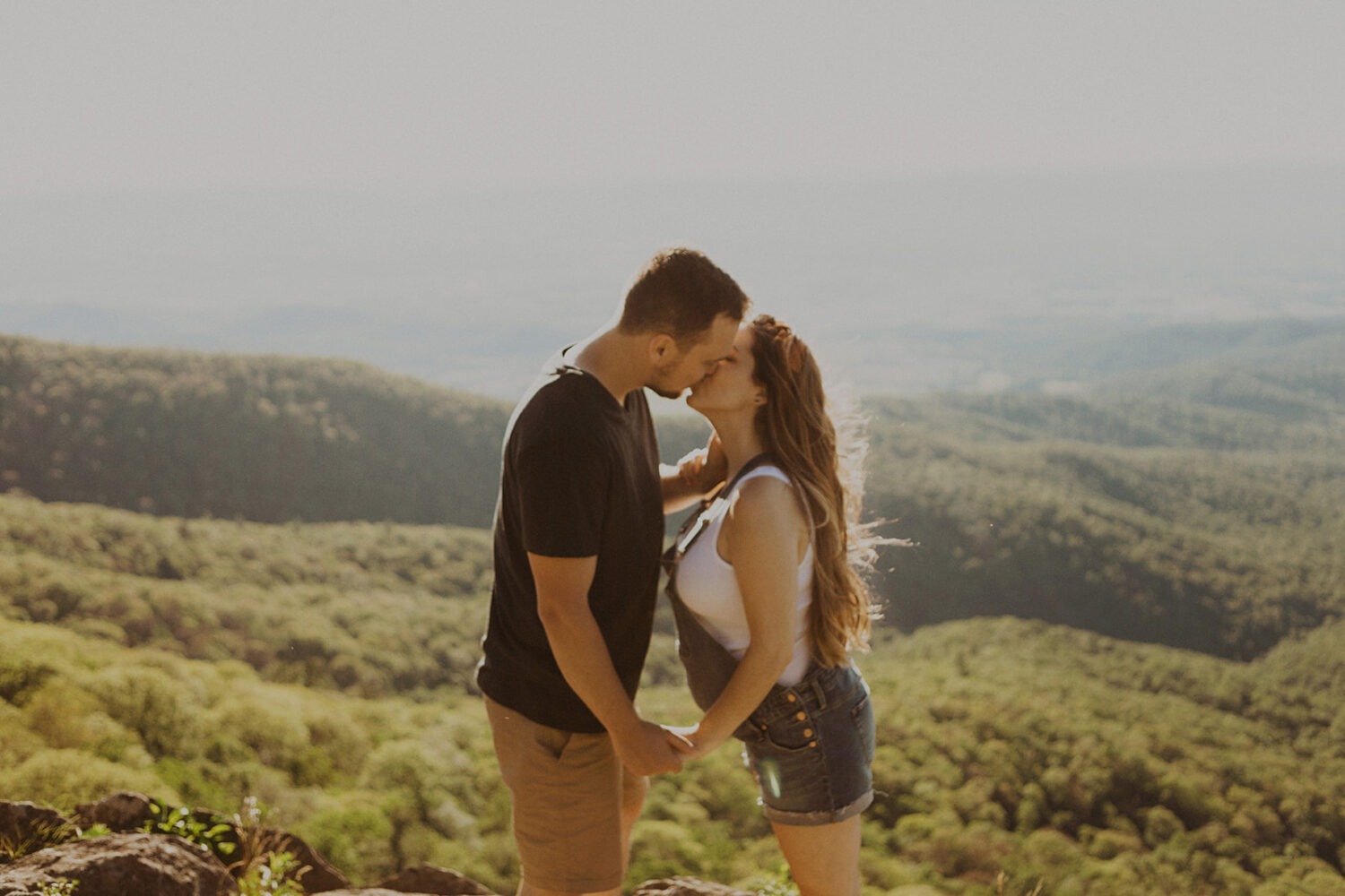 couple kisses on mountaintop at Shenandoah National Park maternity session