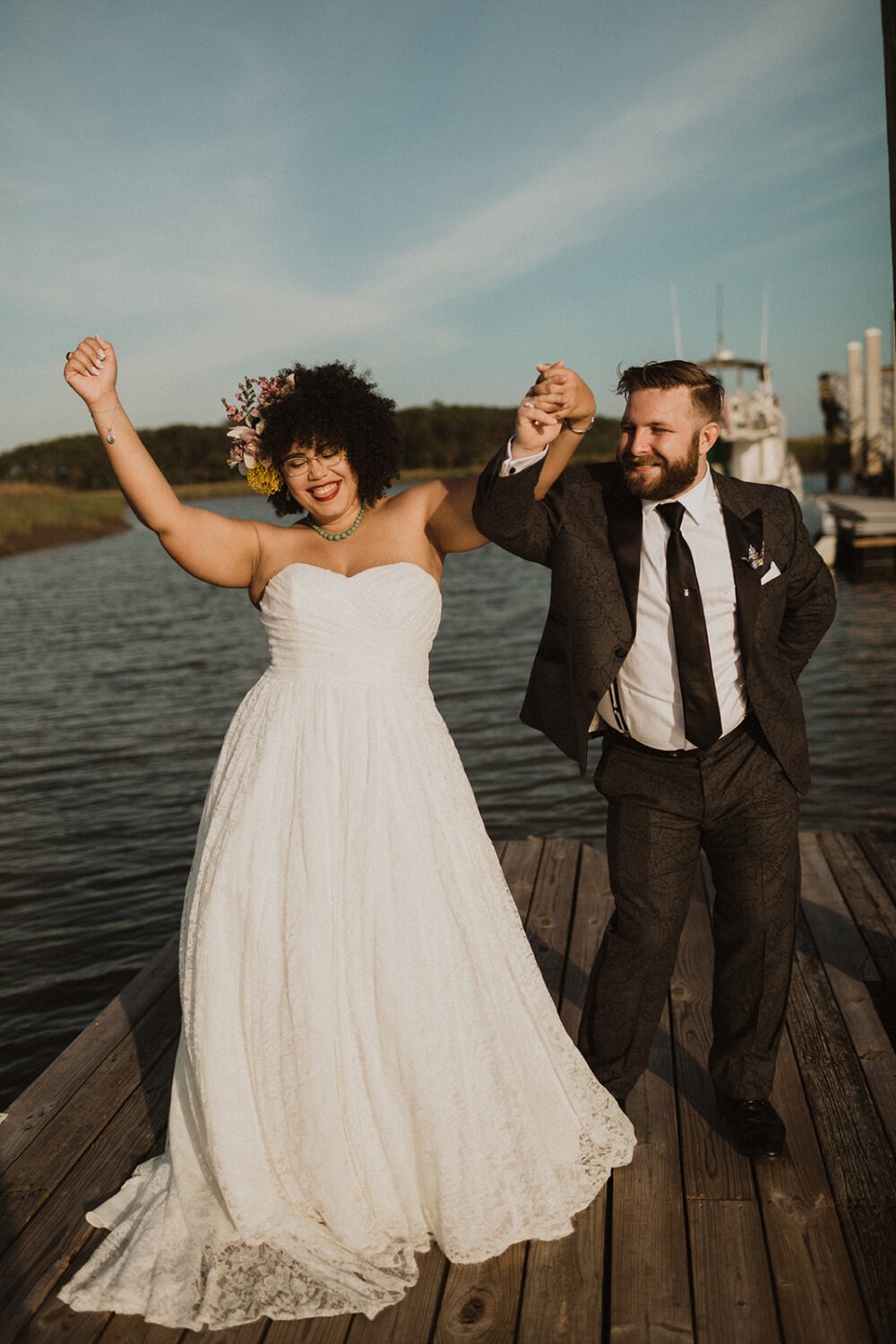 couple dances on deck at sunset waterfront wedding