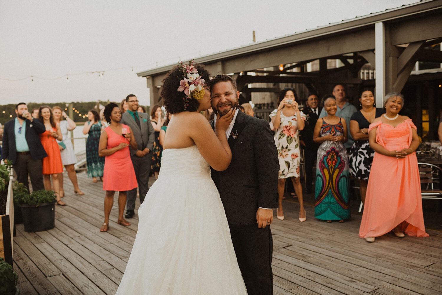 couple kisses at summer wedding at waterfront