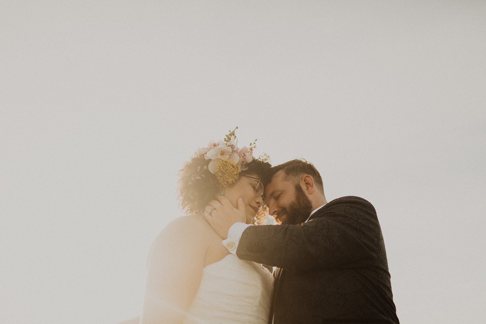 couple embraces in sunset light at summer wedding