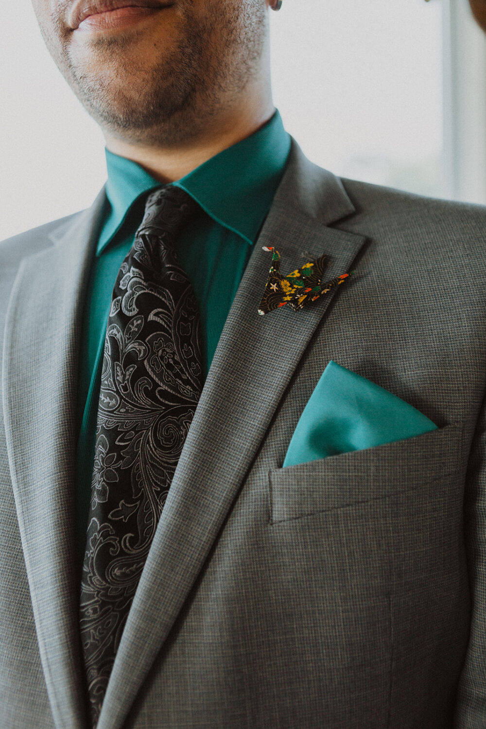 groom wears paper crane boutonniere 