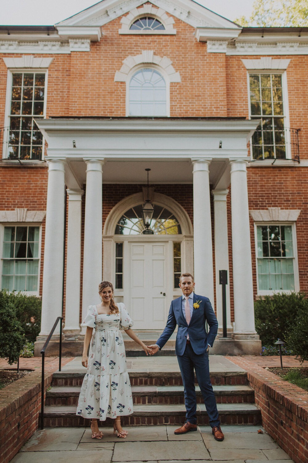 couple holds hands in front of Dumbarton House DC wedding venue