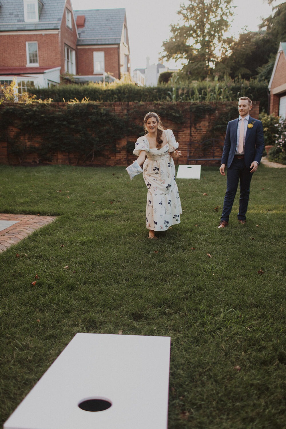 couple plays cornhole at Dumbarton House garden wedding
