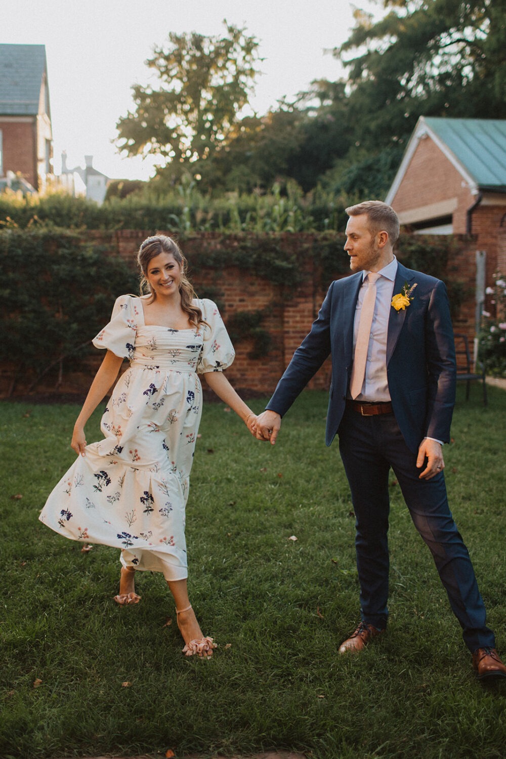 couple walks holding hands in garden at Dumbarton House wedding